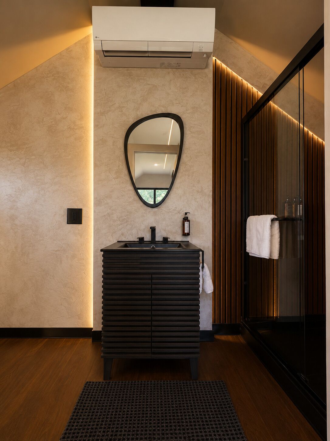 Un baño moderno con tocador, espejo y perchero.
