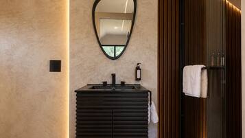 Un baño moderno con tocador, espejo y perchero.