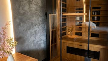 Ein modernes Zimmer mit einer Holzbank, einer Glastrennwand und einem Saunabereich aus Holz.