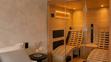 Een moderne slaapkamer met een groot bed, een nachtkastje, een kleine tafel met een vaas en een schuifdeur naar een sauna.