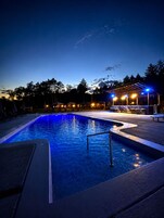 Una piscina al aire libre de temporada, sombrillas