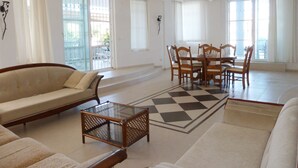 Un salon spacieux comprenant un canapé, une table basse et un coin repas avec des chaises et une table.