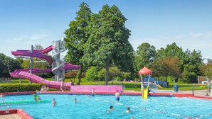 A swimming pool with multiple slides and a playground area. - Amazing home in Heinkenszand with WiFi (Heinkenszand)