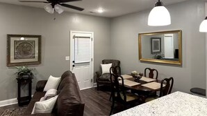 Un comedor con una mesa, sillas, un ventilador de techo y un espejo grande en la pared.