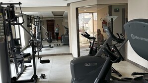 Een sportschool met fitnessapparatuur, waaronder loopbanden en krachttoestellen.