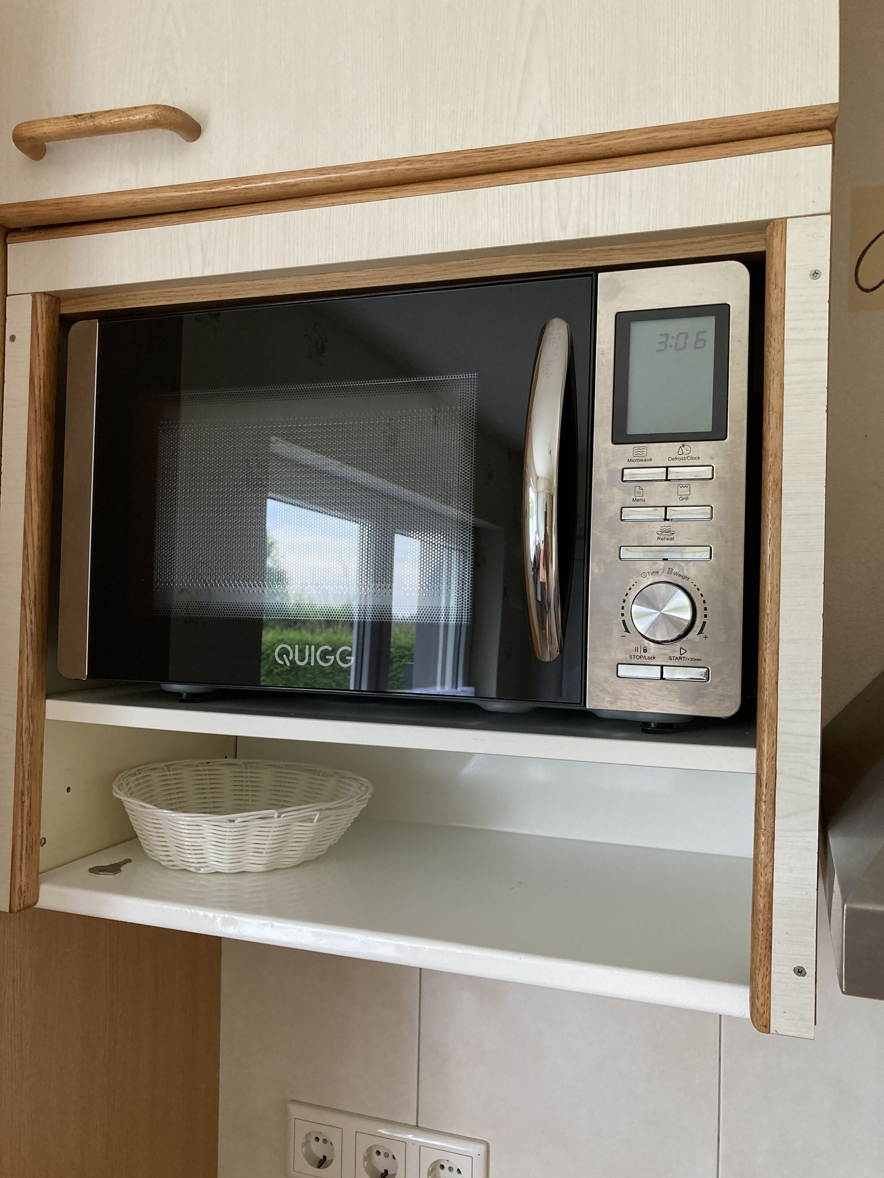 Un four à micro-ondes doté d’un écran numérique, d’un panneau de commande et d’un compartiment situé en dessous.
