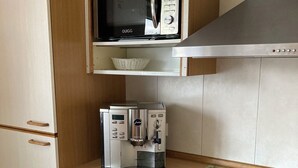 Une cuisine équipée d’un four à micro-ondes, d’une machine à café et d’un four traditionnel.