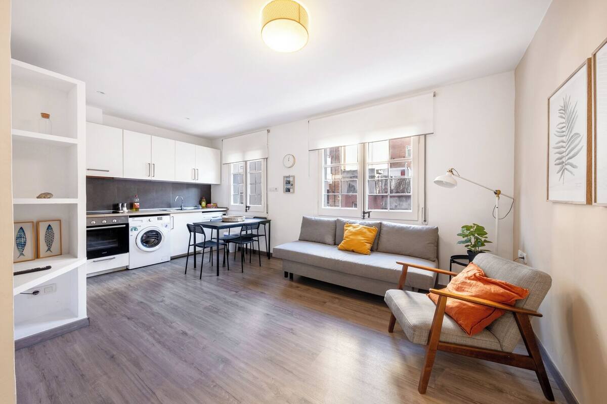 Un appartement compact comprenant une kitchenette, un coin repas et un espace salon.