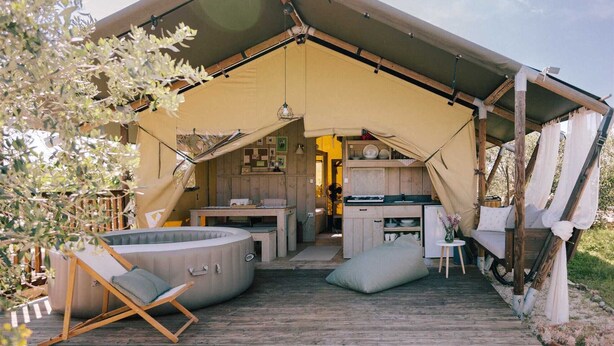 Een tentaccomodatie met een keukenhoek, zitgelegenheid en een jacuzzi.