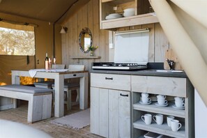 A compact kitchen with a stove, a sink, and a small dining area with a table and chairs.