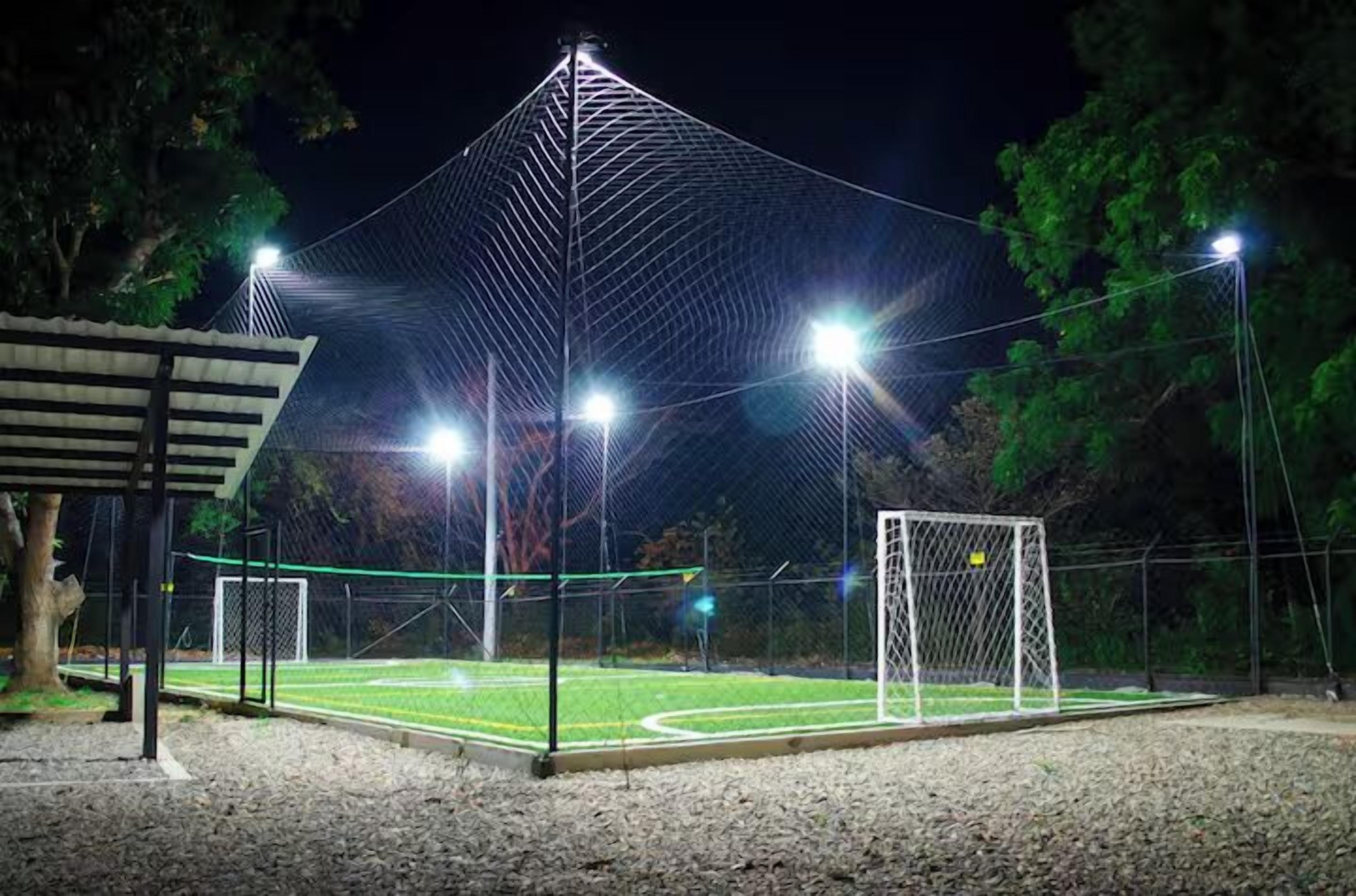 A sports field with a goalpost and floodlights.