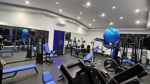 A gym with various exercise equipment, including weight machines and benches. - Finca club las palmas en Girardot (Girardot)