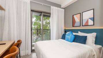 Relax in comfort with a large bed, desk, and artwork-adorned walls.