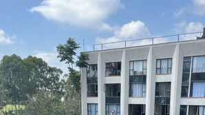 Ein mehrstöckiges Gebäude mit Pool, Außenbereich und Grünflächen.