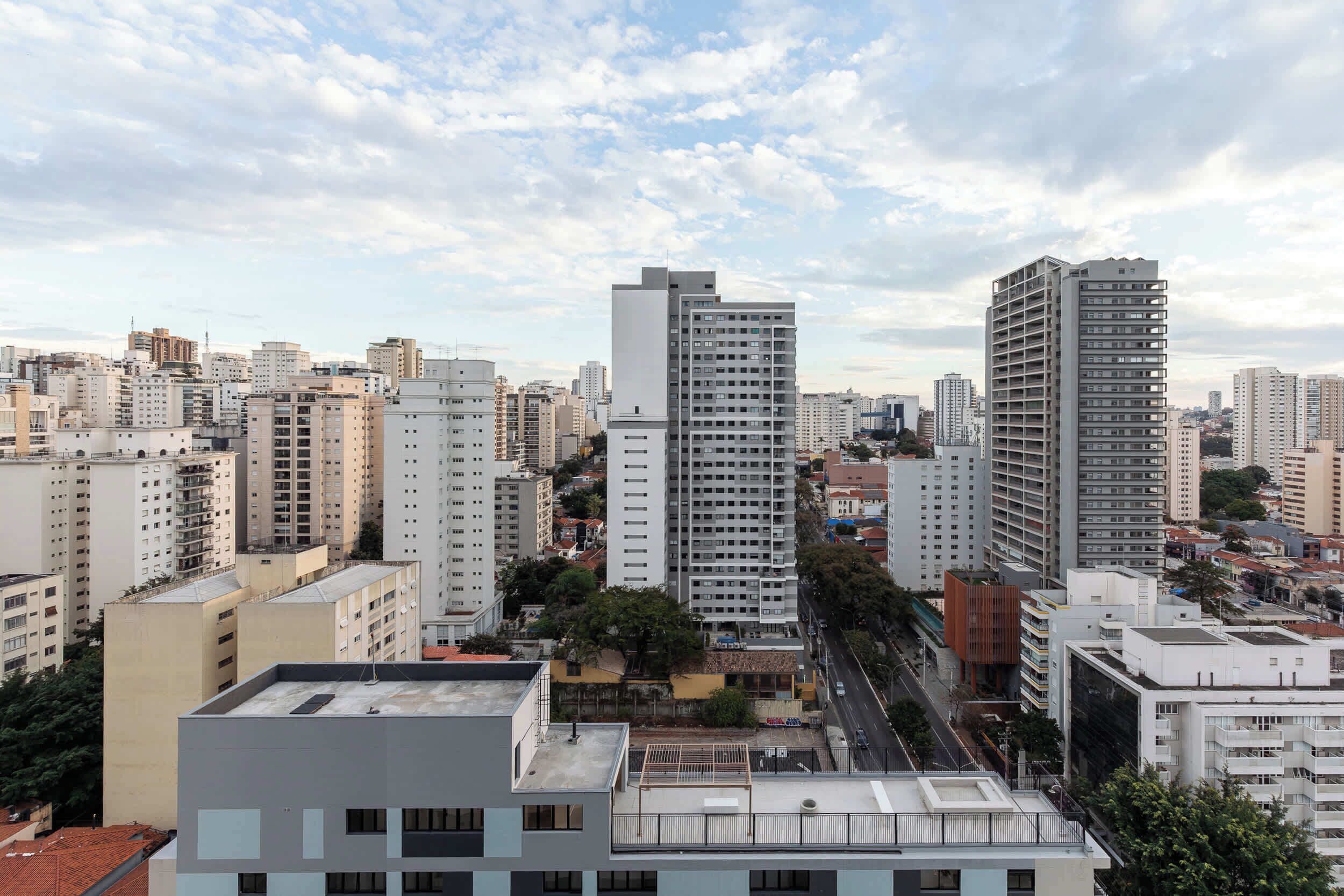 A cityscape with high-rise buildings, a clear sky, and a road.
