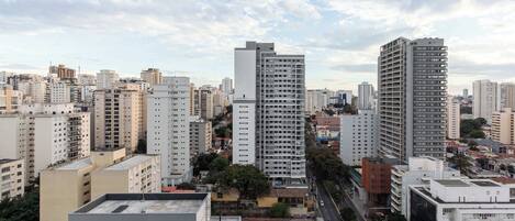 A cityscape with high-rise buildings, a clear sky, and a road.