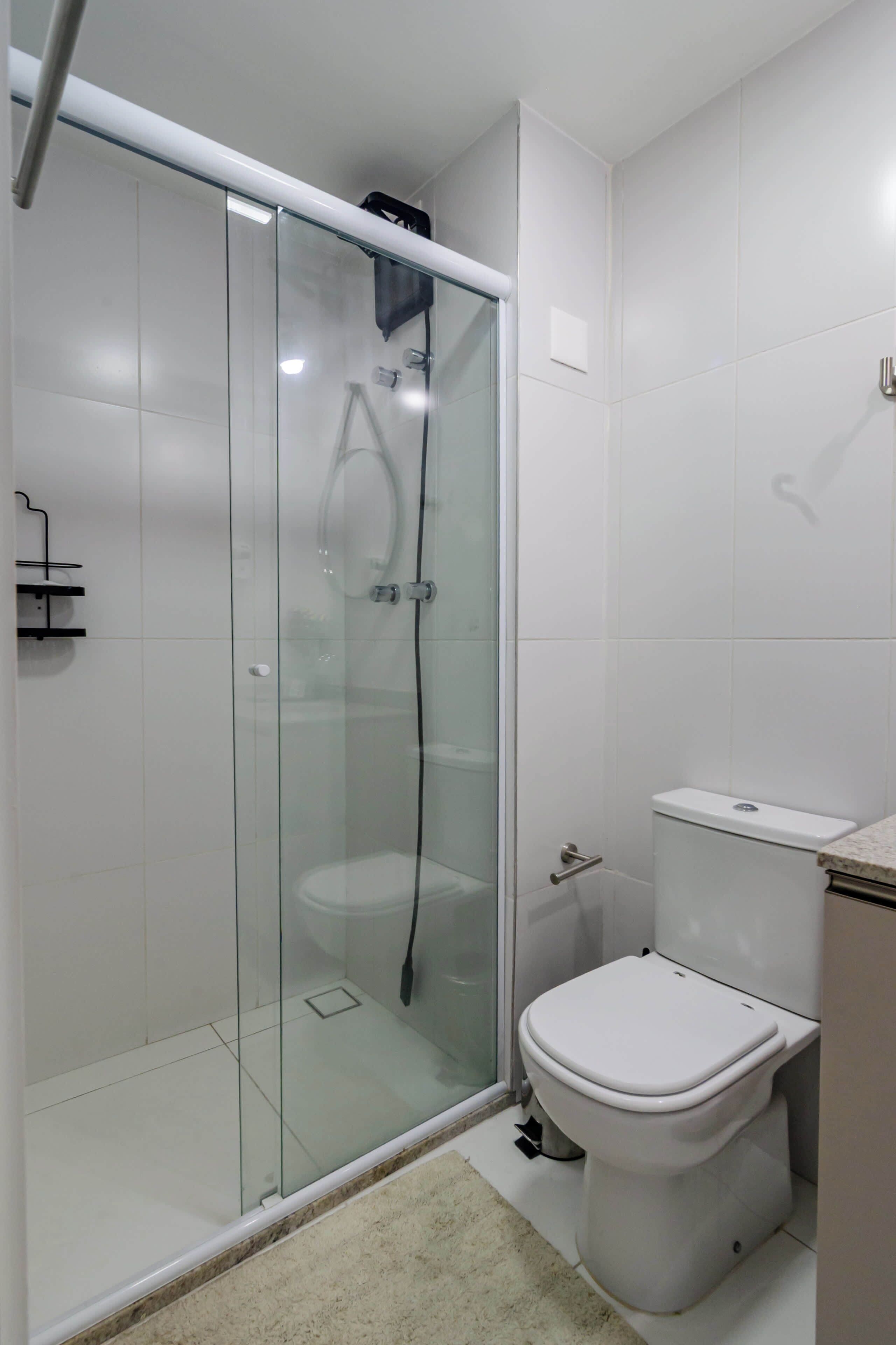 Un bagno moderno con doccia vetrata, un WC bianco e un piano di lavoro in marmo.