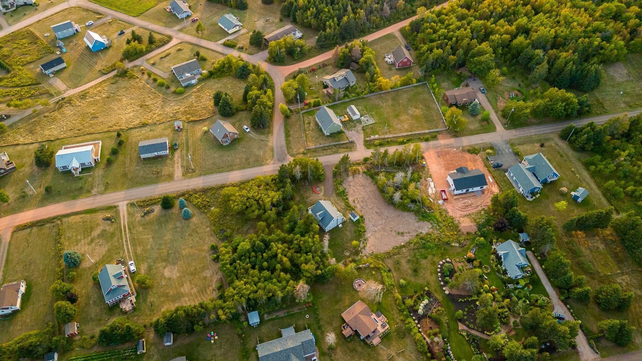 Vista aérea de una zona residencial con varias casas, calles y espacios verdes.