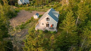 A single-story house with a sloped roof, a front porch, and a small attached garage. - 3-Bedroom Chalet with Kayak in private community - minutes to Cavendish Beach (North Rustico)