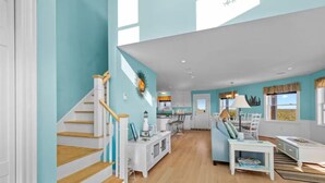 Un vaste espace de vie comprenant un escalier, un coin repas et une cuisine.