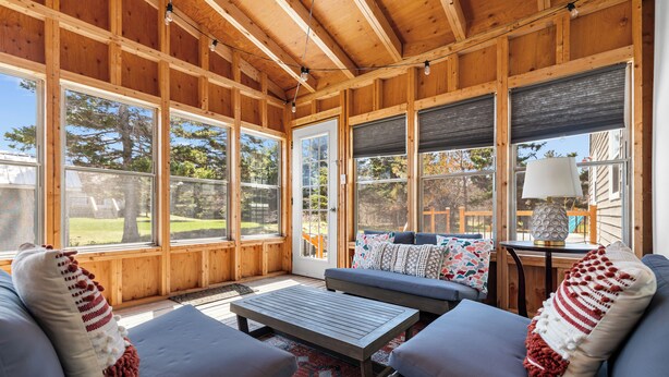 A wooden-paneled room with a sofa, a coffee table, and a lamp. - Family-Friendly Beach House on PEI with Steps to Private Sandy Beach (Morell)