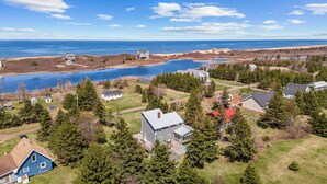 An aerial view of a residential area with houses, a lake, and a beach. - Family-Friendly Beach House on PEI with Steps to Private Sandy Beach (Morell)