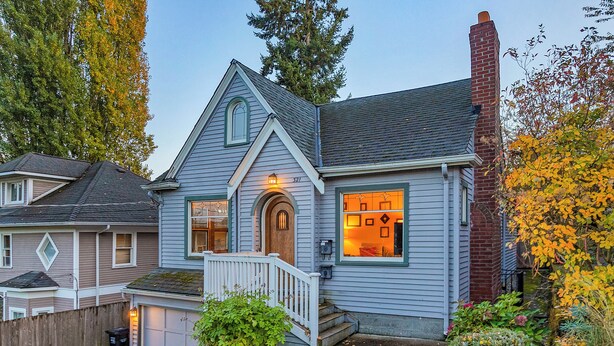 A two-story house with a front porch, a garage, and a brick chimney. - Green Lake Zen Low Level Garden Suite (Seattle)