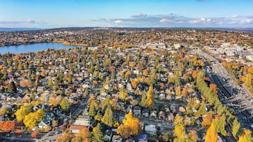 An aerial view of a residential area with houses, a highway, and a body of water.