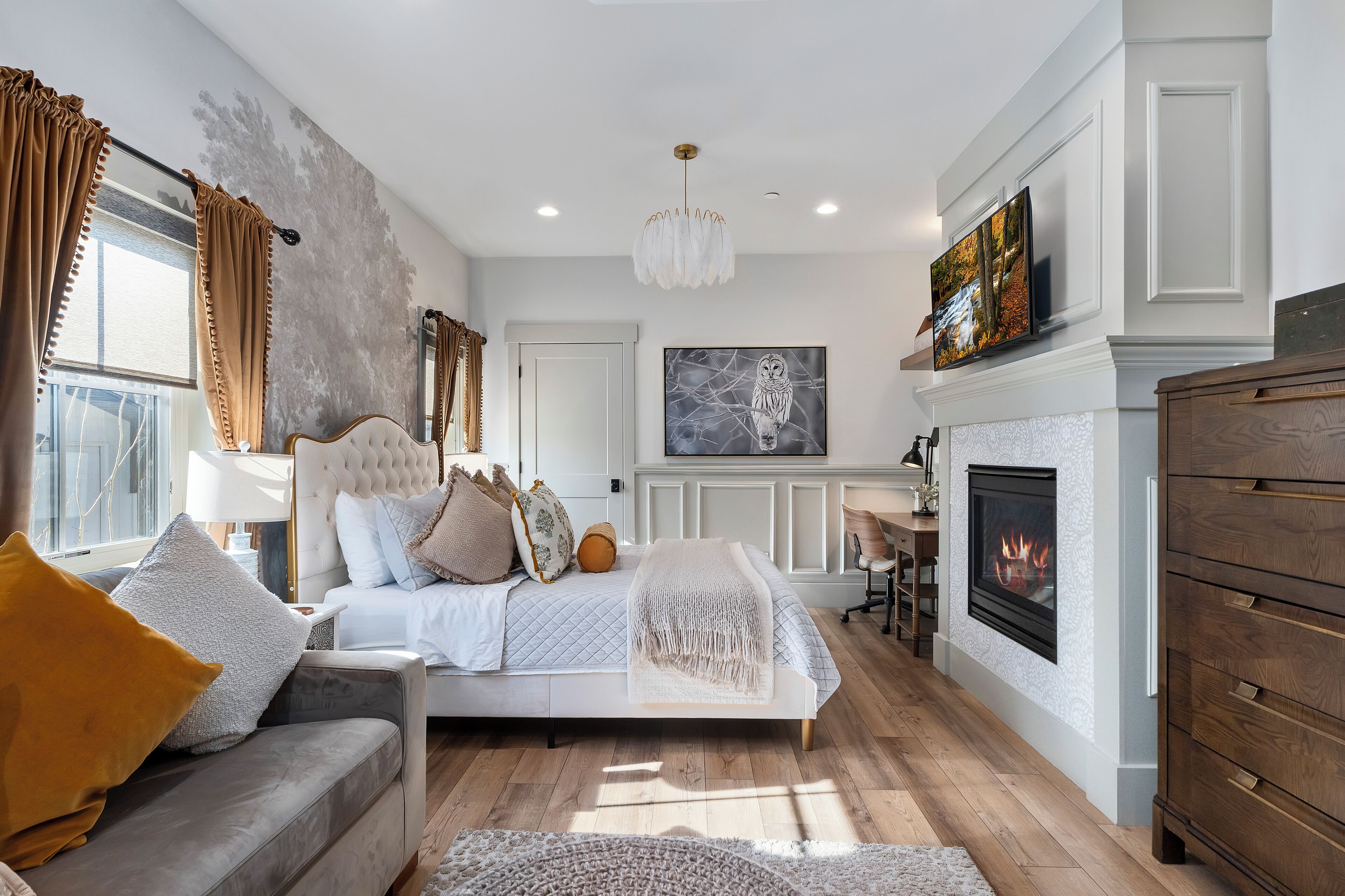 A bedroom with a bed, a fireplace, and a television.