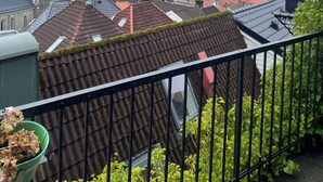 A view of a cityscape with a prominent church tower, a modern hotel, and residential buildings with red-tiled roofs. - City View Bergen. City and sea views from your private terrace. Very central.  (Vestland)