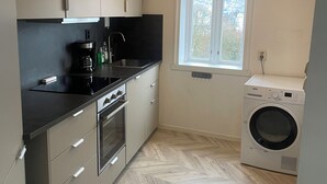 A compact kitchen with modern appliances, a window with a view, and a herringbone-patterned floor. - City View Bergen. City and sea views from your private terrace. Very central.  (Vestland)