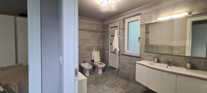 A bathroom with a toilet, bidet, and a sink with a mirror. - VILLA FIORITA STUDIO APARTMENT LAKE VIEW  (Avigliana)