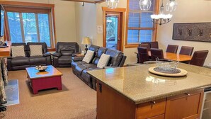 A spacious living area with a large couch, a coffee table, and a kitchen island with a granite countertop. - 5 Min. Drive to the Resort & Fernie. Hot Tub (Fernie)