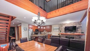 A modern kitchen with wooden cabinets, a built-in oven, and a large TV mounted on the wall. - 5 Min. Drive to the Resort & Fernie. Hot Tub (Fernie)