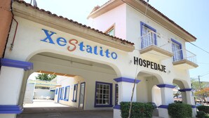 A building with a sign reading "Xestalito Hospedaje" and a covered entrance. - Hotel Xestalito (Santa María Huatulco)