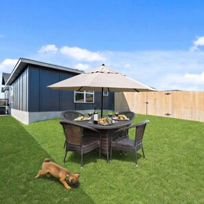 A backyard with a dining table, chairs, and an umbrella. - Ideal for long-term stays-available for 14 days and Beyond. (Temple)
