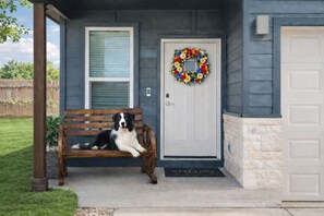 A house with a front porch, a bench, a dog, and a wreath on the door. - Ideal for long-term stays-available for 14 days and Beyond. (Temple)