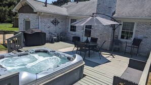A backyard with a hot tub, outdoor furniture, and a covered patio area. - Hot Tub - Fire Pit - Single Level Ranch (Matthews)