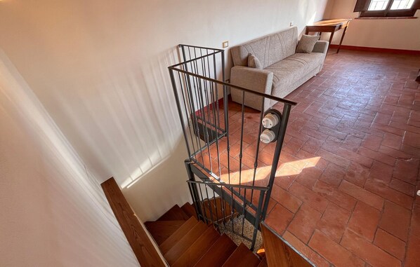 A staircase with metal railings leading to a room with a sofa and a table.