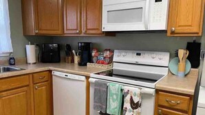 A kitchen with wooden cabinets, a microwave, a dishwasher, and a stove. - Easy Checkout--Safe & Comfy 3BR--King Bed--Pets OK (Rockwood)