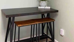 A dark wooden table with a bench, two decorative panels on the wall, and a potted plant. - Easy Checkout--Safe & Comfy 3BR--King Bed--Pets OK (Rockwood)