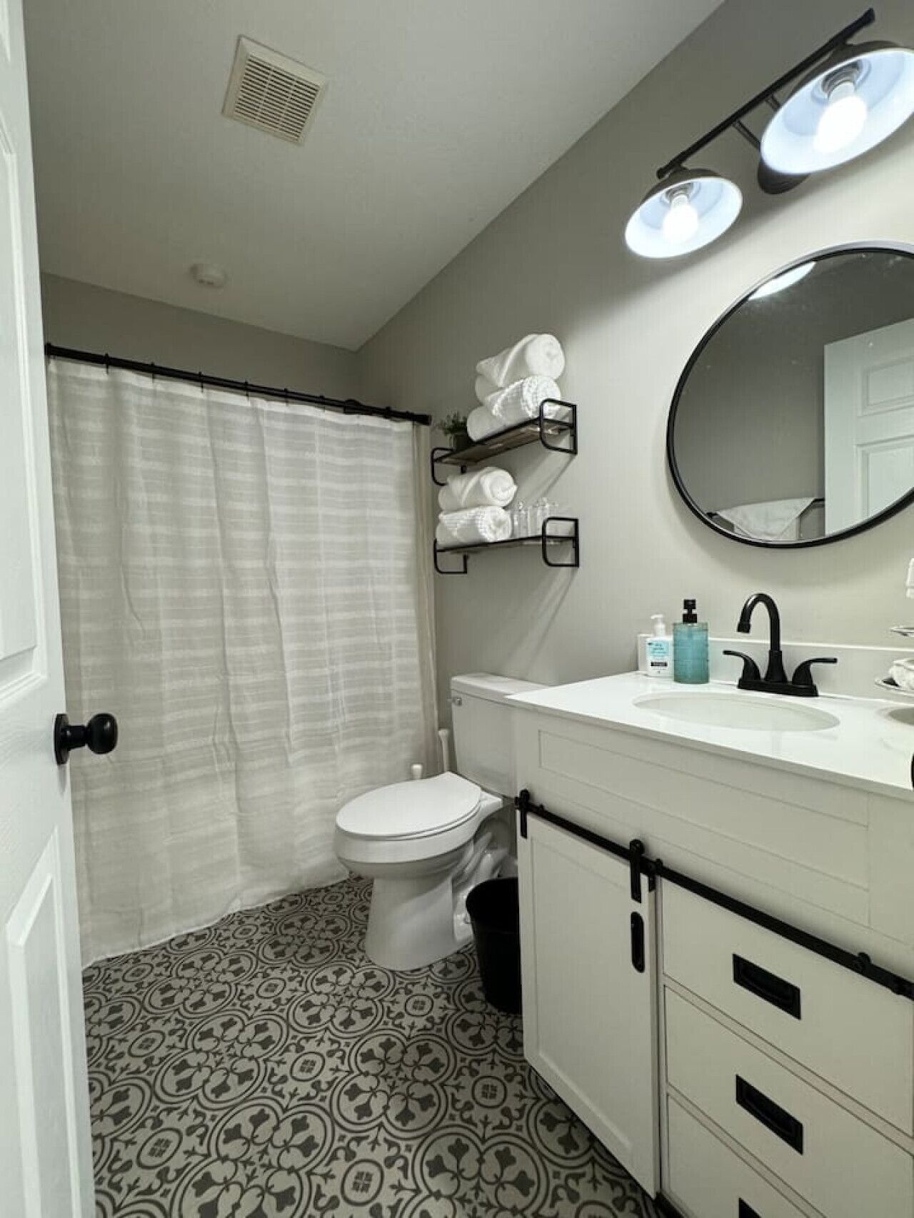 Een badkamer met toilet, wastafel, spiegel en douchegordijn.