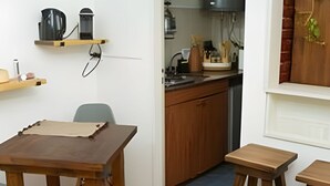 A compact kitchen with wooden cabinets, a built-in oven, and a coffee machine. - Home in downtown-Maipu St. (Buenos Aires)