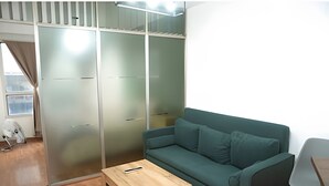 A room with a green sofa, a wooden coffee table, and a sliding glass door closet. - Home in downtown-Maipu St. (Buenos Aires)