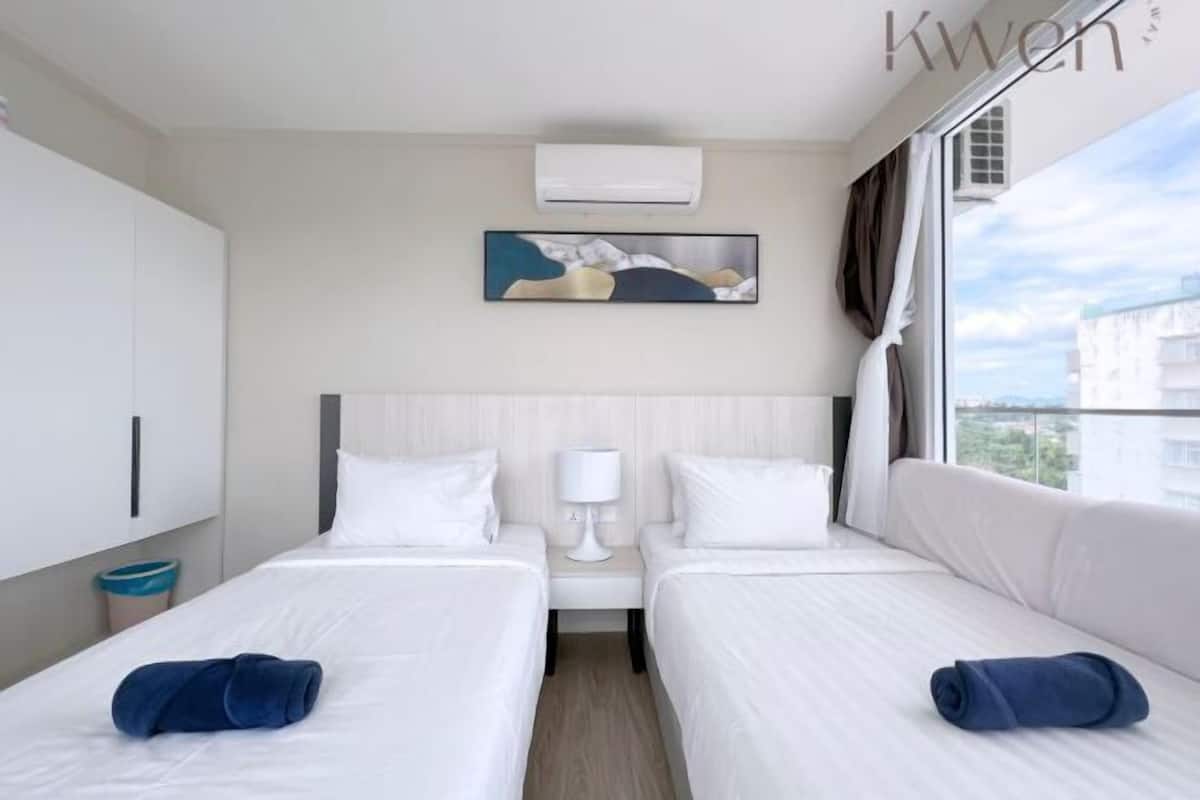 Une chambre d’hôtel avec deux lits, un tableau, un climatiseur et une vue sur la ville.