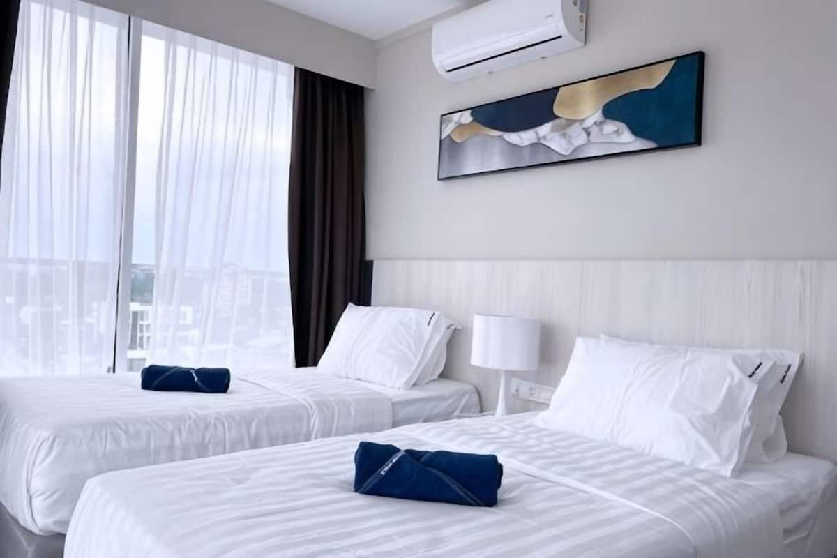 Une chambre d’hôtel avec deux lits, une vue sur la ville, un tableau au mur et un appareil de climatisation.