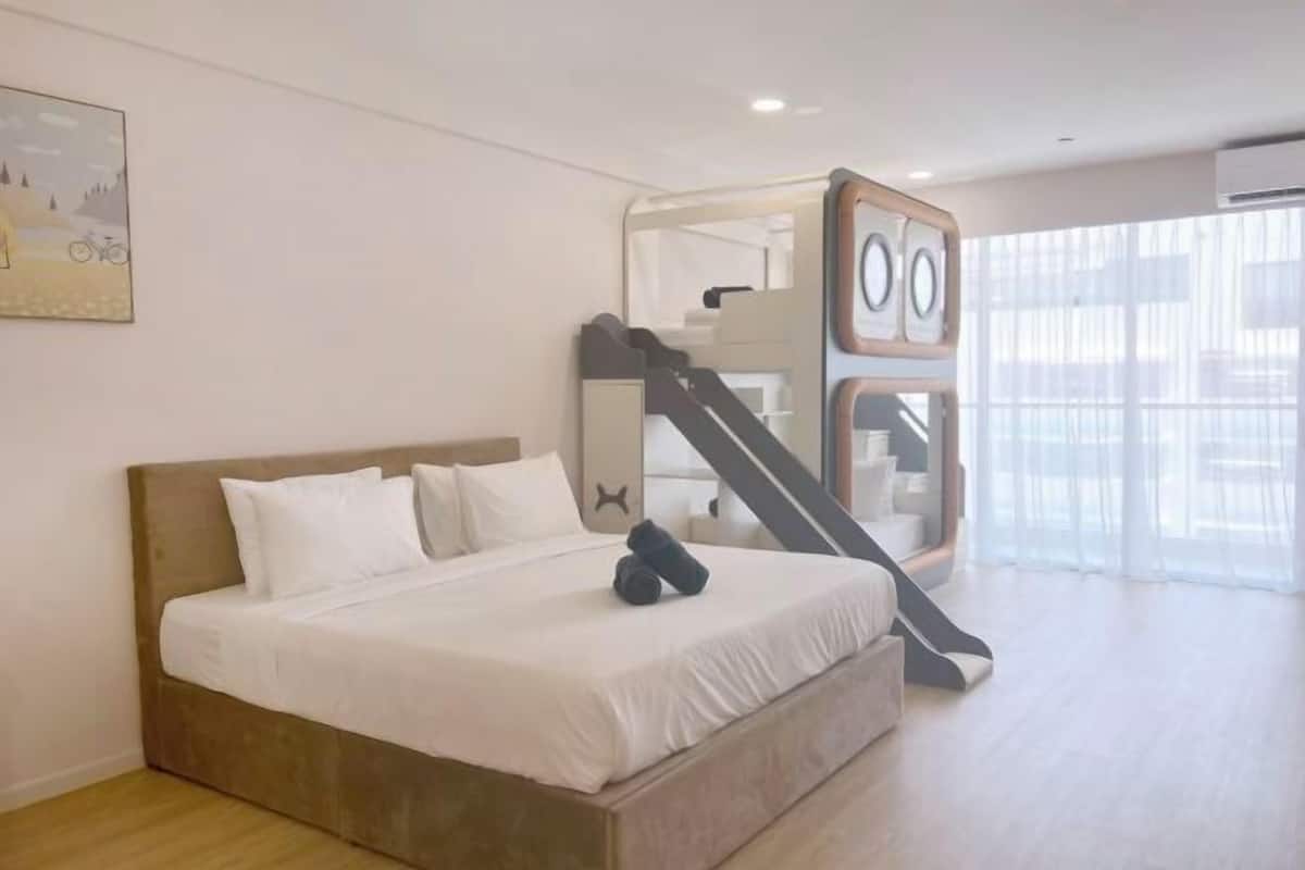 Une chambre à coucher avec un lit, un escalier et une grande fenêtre.
