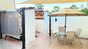An outdoor patio with a table and chairs, a pergola with a canopy, and a view of the surrounding area. - Carolina Green House (Carolina)