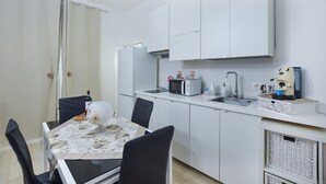 A compact kitchen with white cabinets, a microwave, a kettle, and a coffee machine. - 1 bedroom nice home in Siracusa (Siracusa)