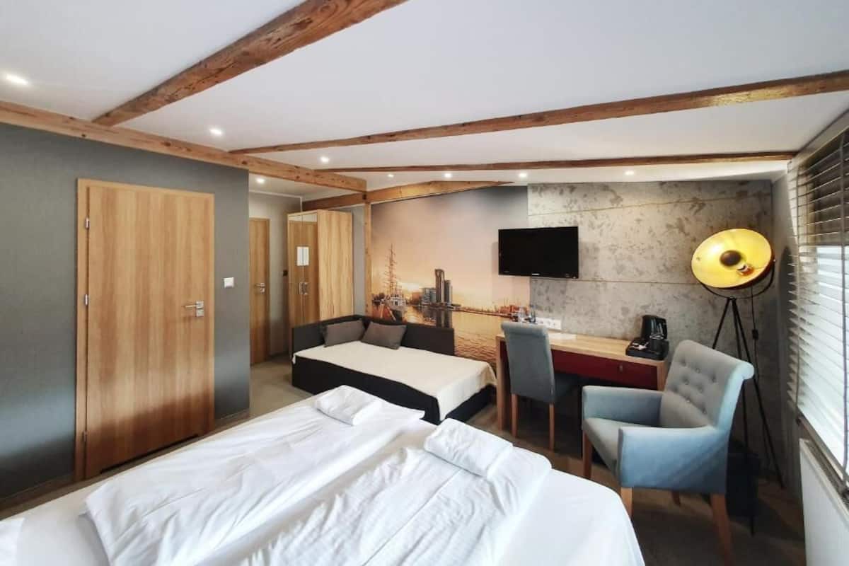 Une chambre d’hôtel comprenant un lit, un bureau avec une chaise, une télévision et une lampe.